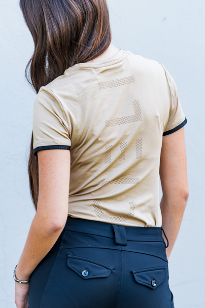 Person wearing a mocha shirt with black trim and navy pants against a light gray background