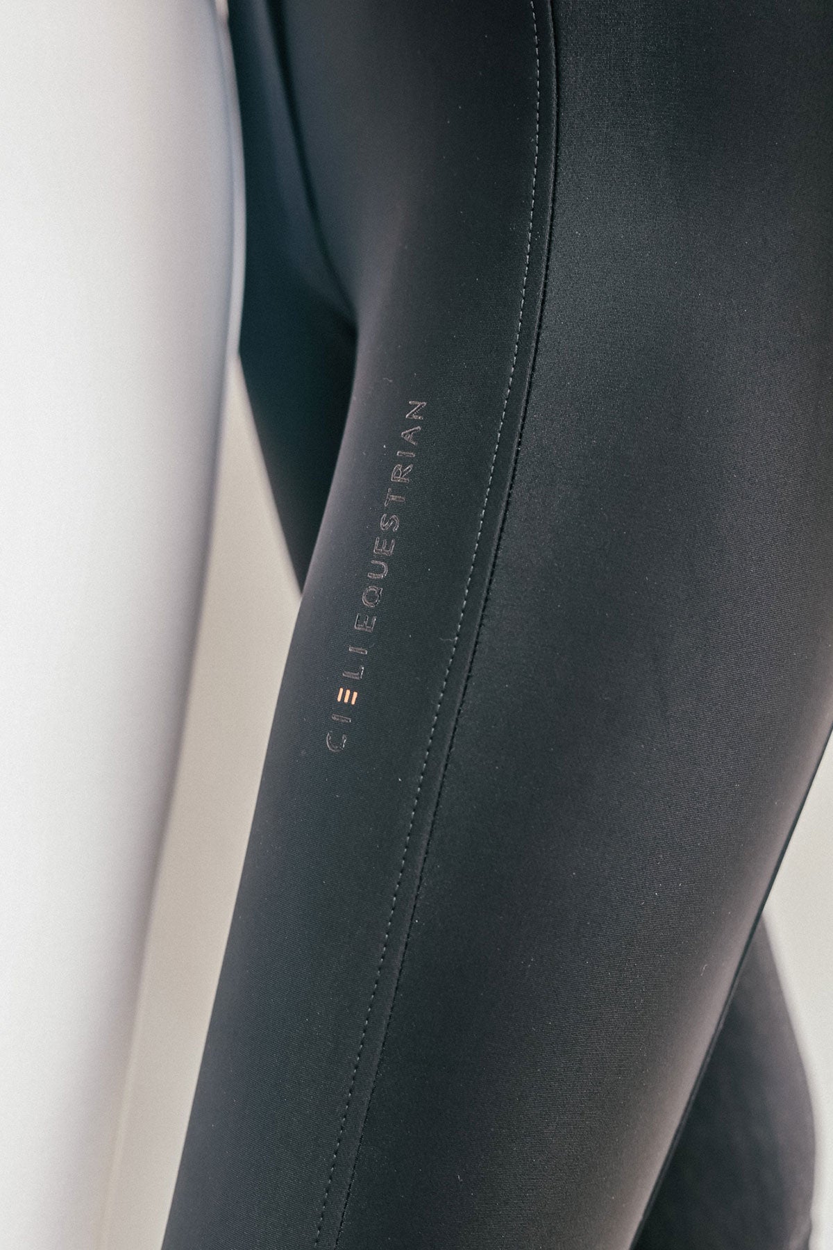 Close-up of black equestrian pants with 'Cieli Equestrian' branding on a white background