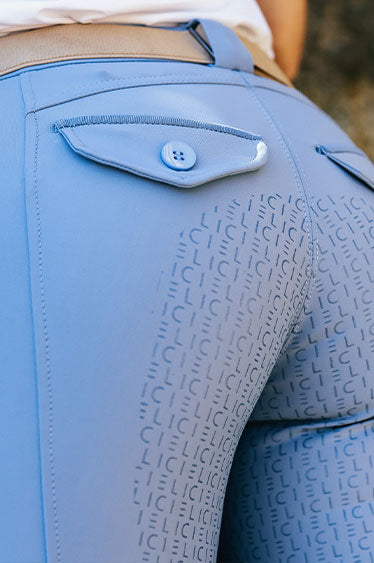 Close-up of blue equestrian pants with a Cieli brand logo pattern.