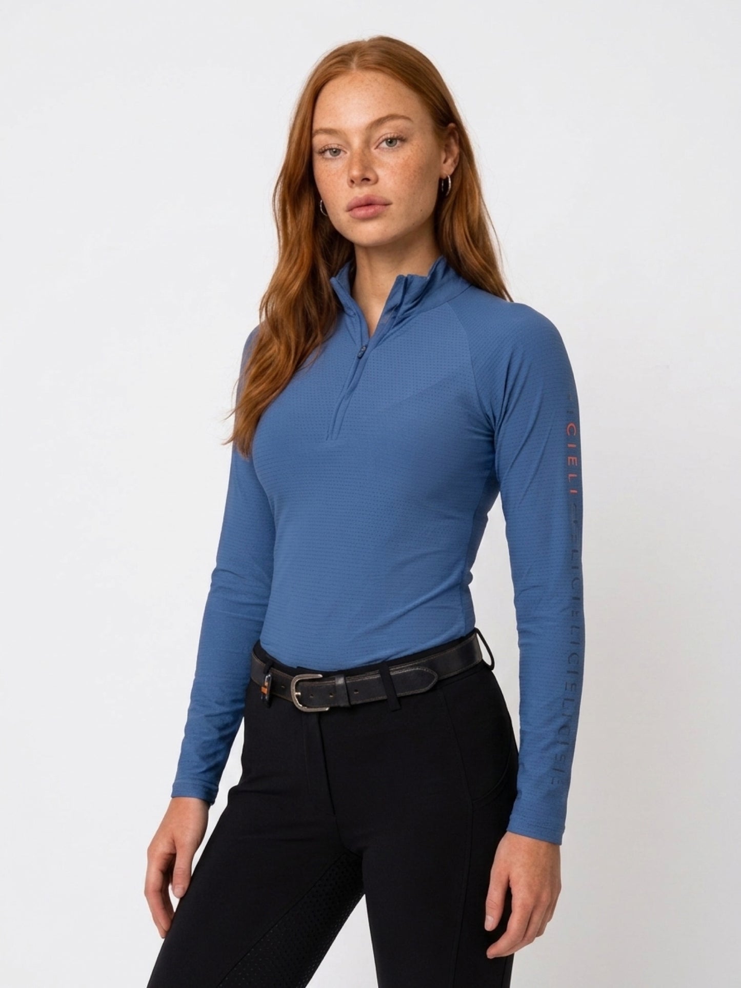 The Faye Baselayer in blue with a quarter-zip collar and long sleeves.
