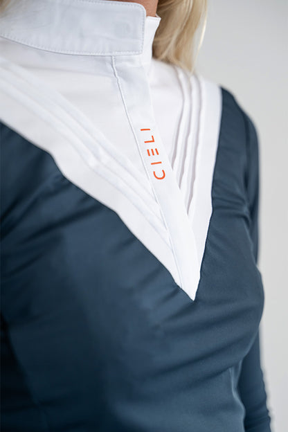 Close-up of a person wearing a dark navy long-sleeve top with a large white V-shaped collar or neck panel. The wordmark 'CIELI' appears vertically in orange on the white panel.