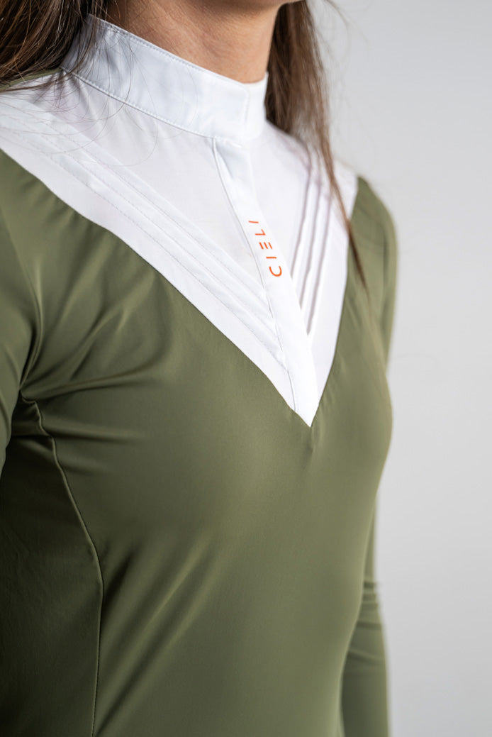 Close-up of an equestrian wearing a green and white long-sleeve show shirt with a high collar and the brand name 'CIELI' printed in orange on the chest.