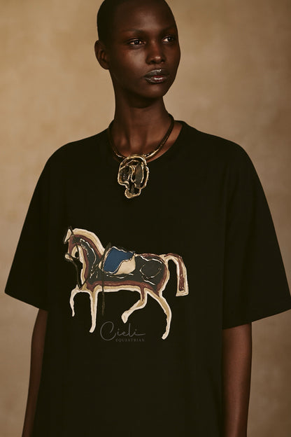 Person wearing a black t-shirt with a horse design on a beige background