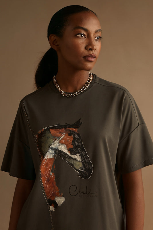 Woman wearing a dark green t-shirt with a horse graphic and 'Cieli' branding on a beige background