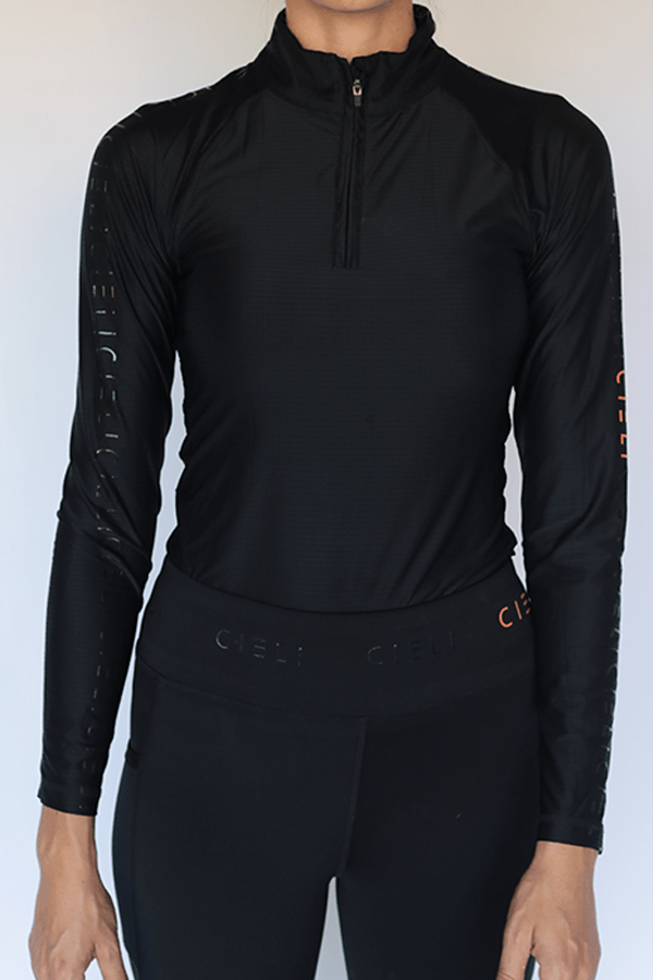 The Faye Baselayer in black with a quarter-zip collar and long sleeves.
