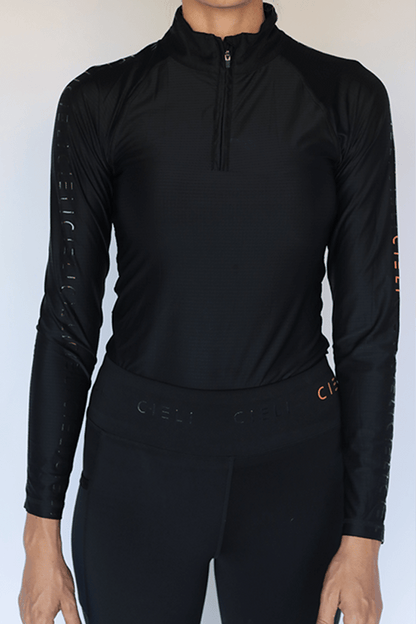 The Faye Baselayer in black with a quarter-zip collar and long sleeves.